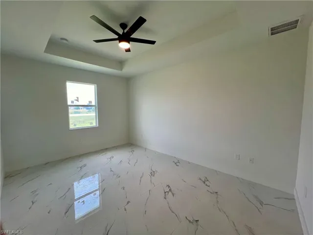 Primary Bedroom room with a tray ceiling and ceiling fan
