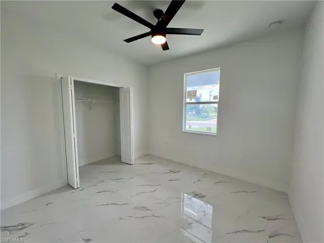 Bedroom with ceiling fan and a closet