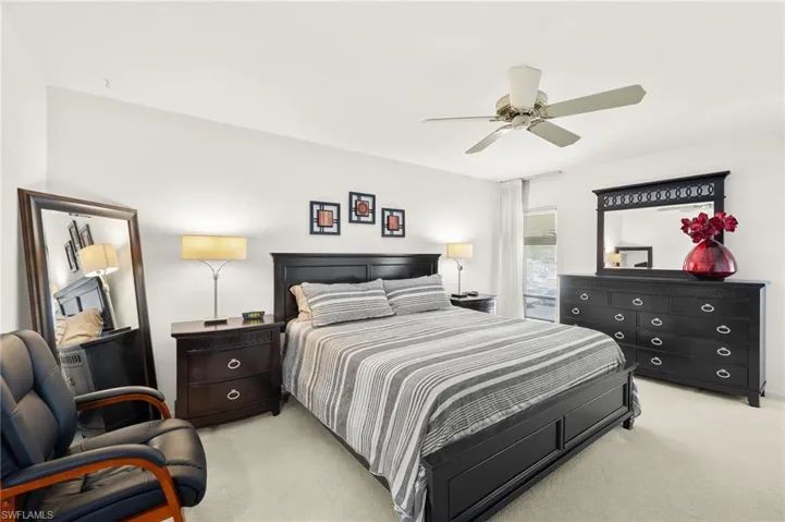 Bedroom with light colored carpet and a ceiling fan