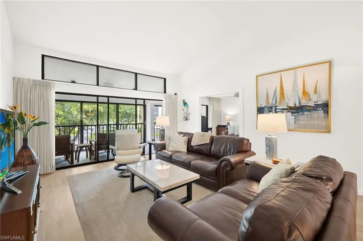 Living room with high vaulted ceiling and wood finished floors