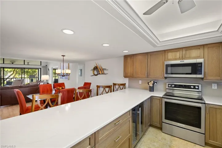 Kitchen with stainless steel appliances, open floor plan, recessed lighting, and beverage cooler