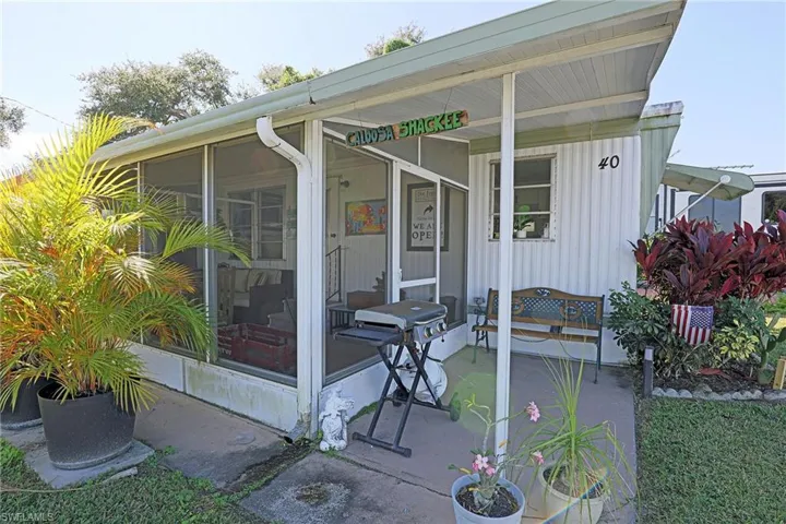View of patio with area for grilling and a sunroom