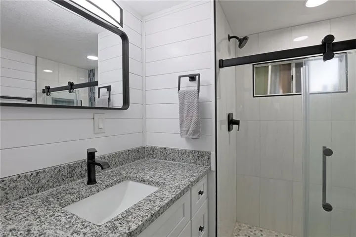 Full bathroom featuring vanity, a stall shower, and recessed lighting