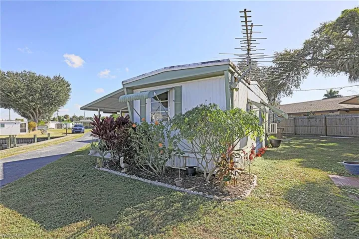 View of property exterior featuring an attached carport and driveway