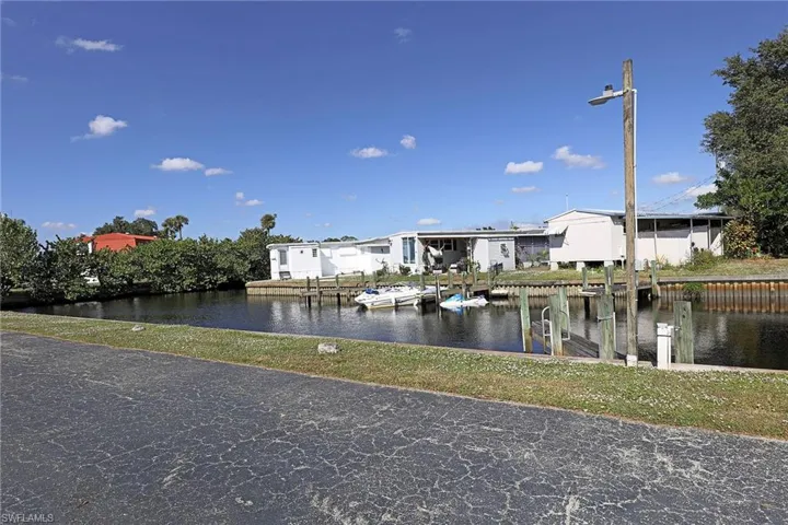 Dock with a water view, boat lift, and a residential view