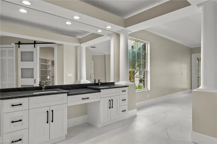 Bathroom with ornamental molding, vanity, and decorative columns