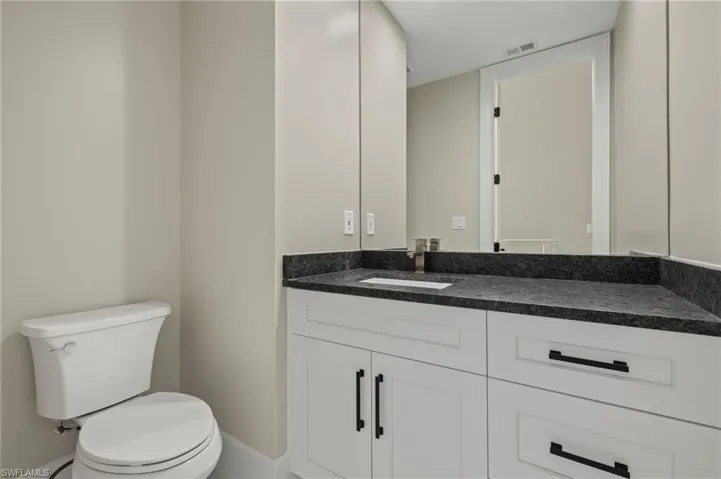 Guest half-bathroom featuring vanity and toilet