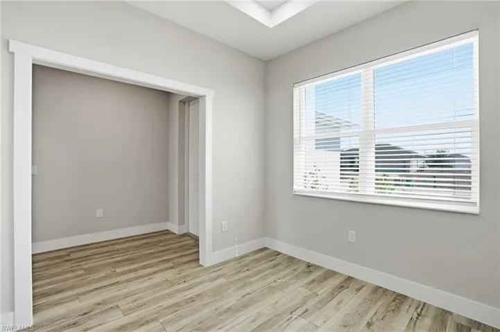 Unfurnished room featuring light wood finished floors and baseboards