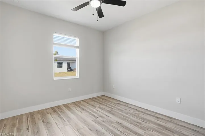 Empty room with light wood-style floors and ceiling fan