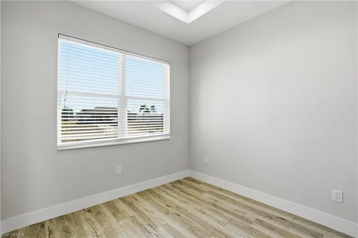 Spare room with baseboards and light wood-style floors