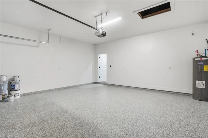 Garage featuring water heater and baseboards