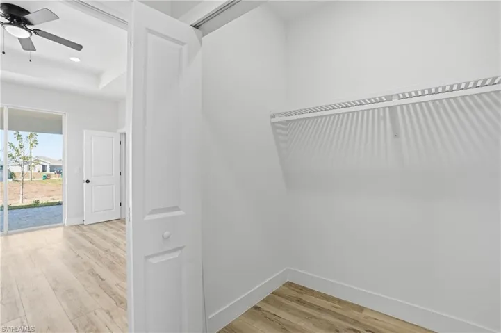 Walk in closet featuring light wood-style floors and ceiling fan