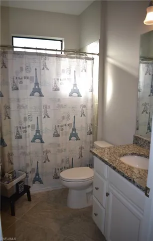 Bathroom featuring a shower with curtain and vanity