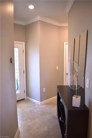 Hall with ornamental molding and recessed lighting