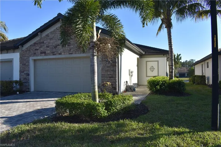 Single story home featuring stucco siding, stone siding, and decorative driveway