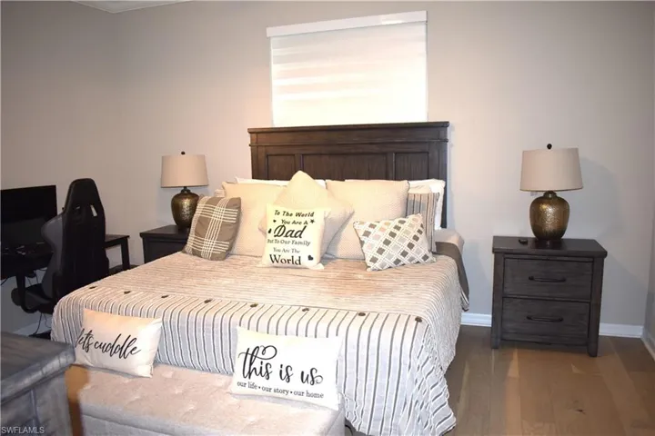 Bedroom with wood finished floors and baseboards