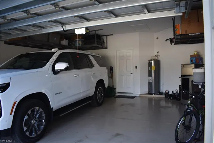 Garage featuring water heater and a garage door opener