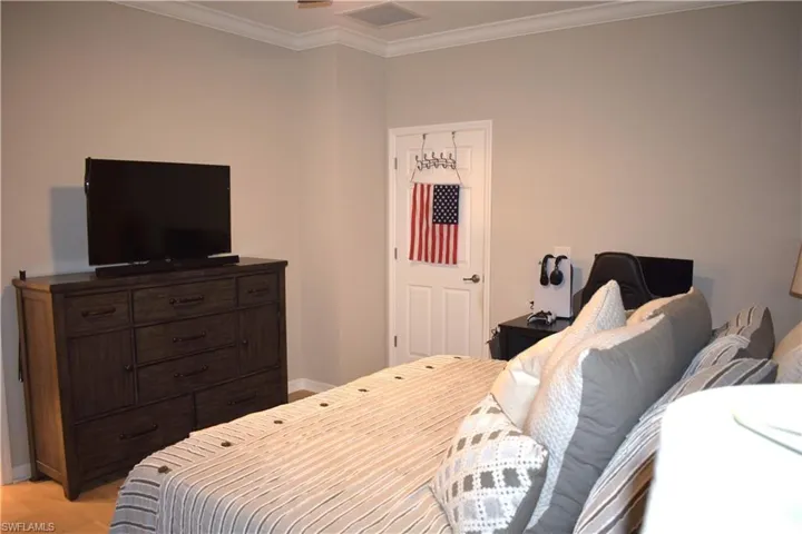 Bedroom with ornamental molding and light wood-type flooring
