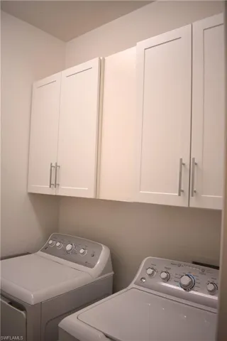 Laundry room with cabinet space and washer and clothes dryer