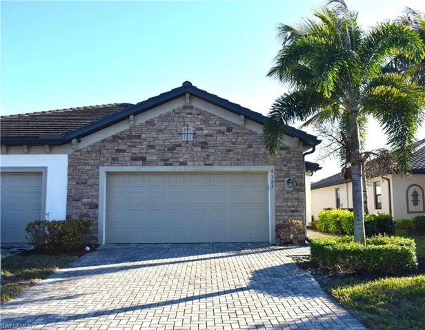 View of front of house with decorative driveway, an attached garage, and stucco siding