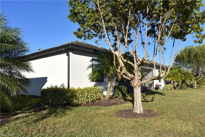 View of side of home featuring a lawn and stucco siding