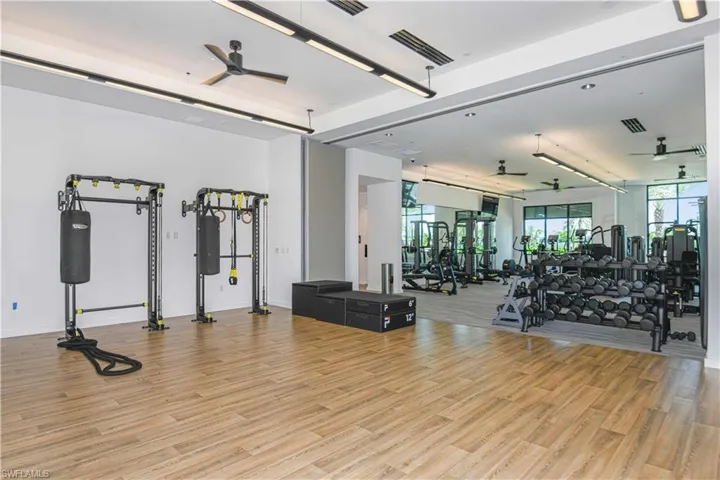 Exercise room featuring ceiling fan and light hardwood / wood-style floors