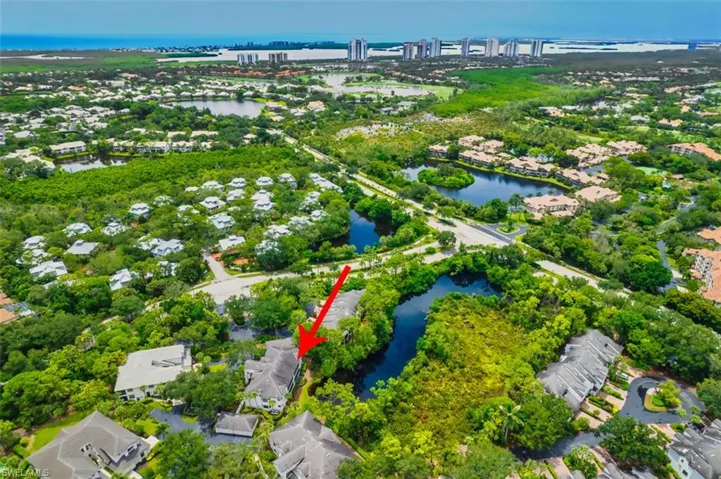 Aerial view of property's location featuring a nearby body of water and nearby suburban area