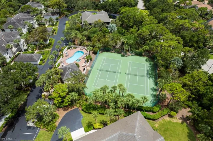 Aerial view of residential area with a pool area and tennis courts