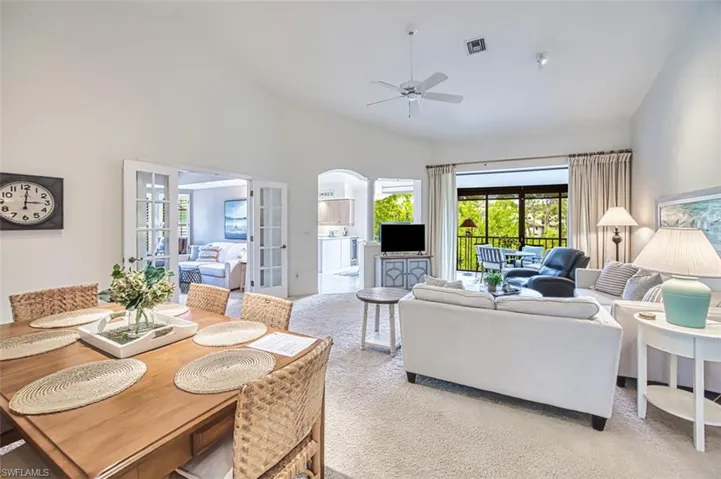 Living area featuring a ceiling fan, carpet floors, and french doors