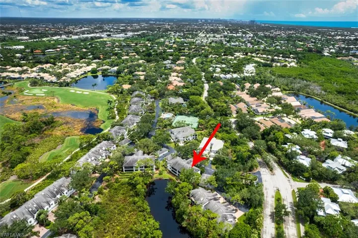 Aerial overview of property's location featuring nearby suburban area, a large body of water, and a golf course