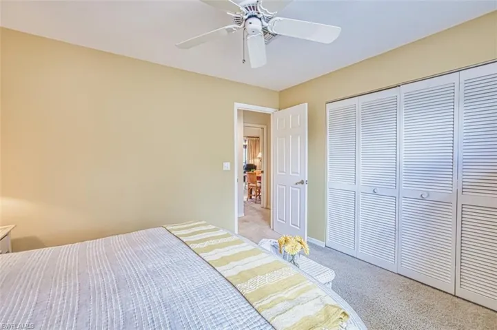Bedroom featuring light colored carpet, a closet, and ceiling fan