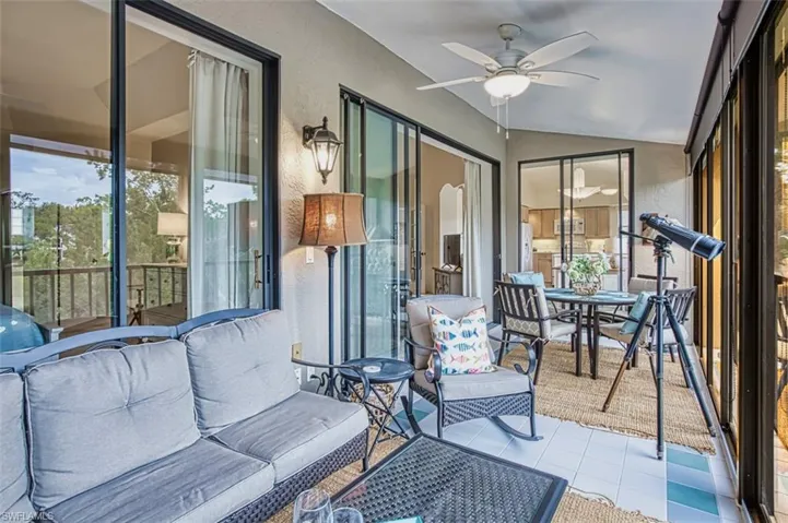 Sunroom featuring lofted ceiling, a ceiling fan, and outdoor dining space