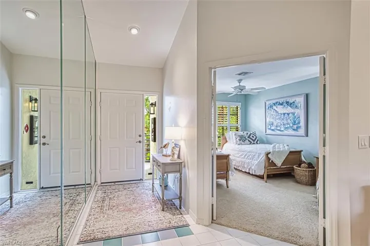 Foyer with carpet floors, tile patterned floors, and recessed lighting