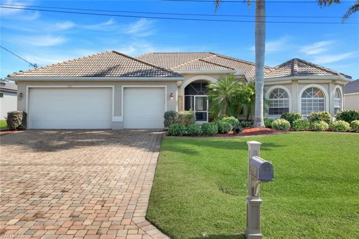 View of front facade featuring decorative driveway, a front lawn, stucco siding, an attached garage, and a tile roof