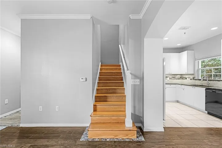 Hardwood staircase with white risers and handrail