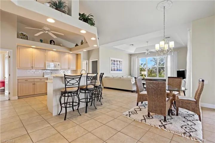 Tiled dining space featuring a chandelier, and vaulted ceiling