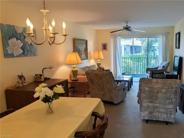 Carpeted dining room featuring a chandelier