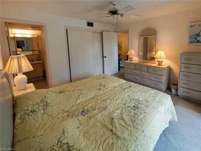 Carpeted bedroom featuring a closet and a ceiling fan