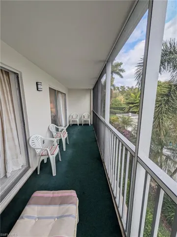 Sunroom / solarium with floor to ceiling windows, carpet, and a balcony