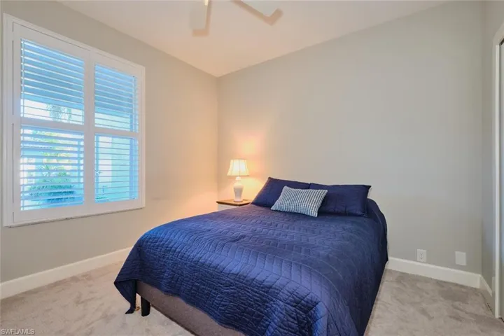 Bedroom with ceiling fan and light carpet