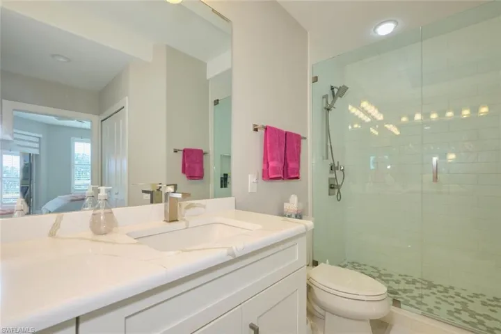 Bathroom with walk in shower, vanity, and toilet