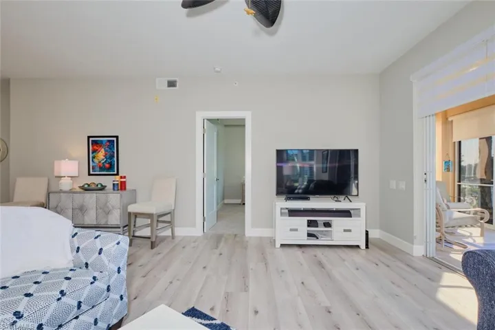 Living room with ceiling fan and light wood-type flooring