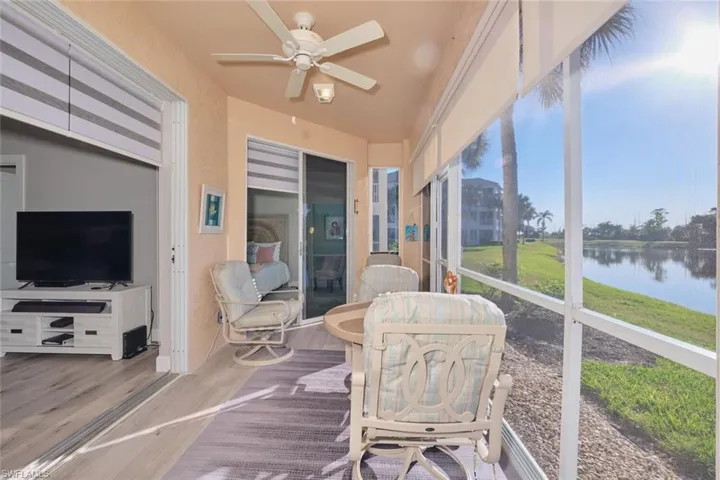 Sunroom featuring plenty of natural light, ceiling fan, and a water view