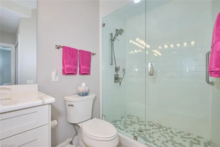 Bathroom with vanity, toilet, and an enclosed shower