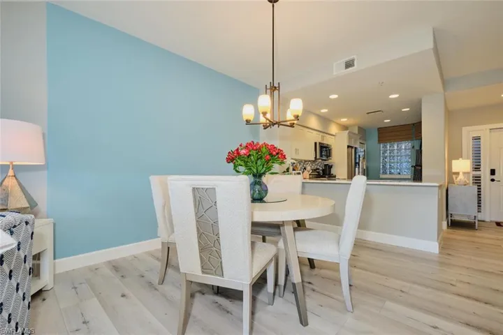 Dining area featuring light wood-type flooring and a notable chandelier