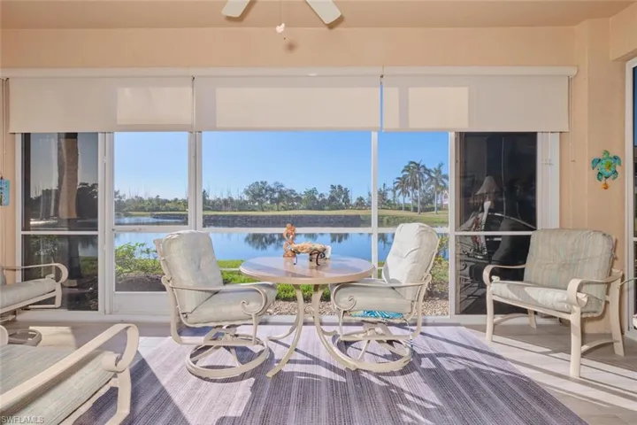 Sunroom featuring ceiling fan and a water view