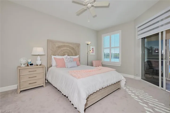 Carpeted bedroom featuring ceiling fan and access to outside