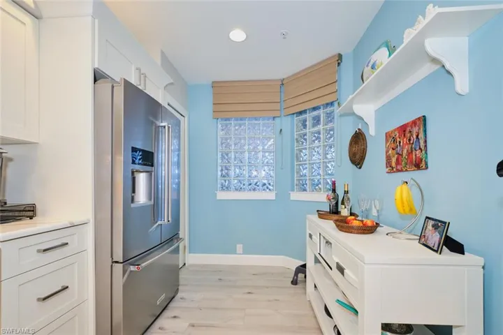 Kitchen featuring white cabinetry, high end fridge, and light hardwood / wood-style floors