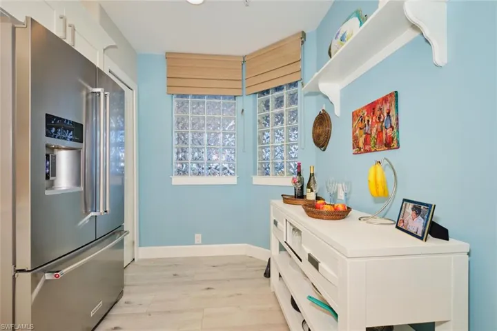Kitchen featuring high quality fridge, white cabinets, and light wood-type flooring