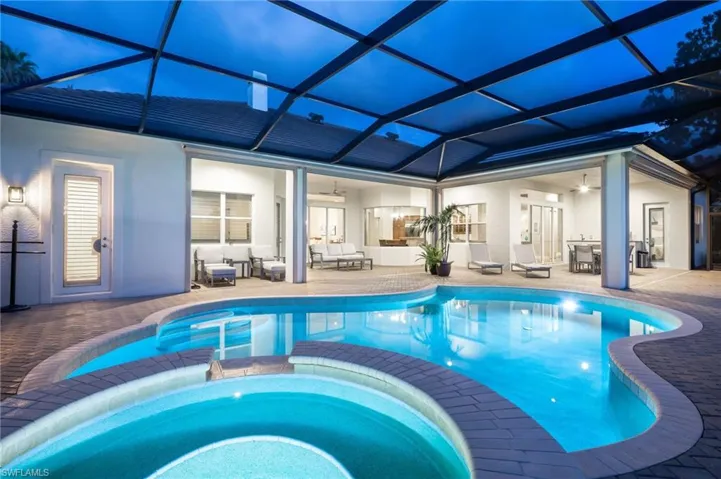 View of pool with a ceiling fan, a sunroom, a pool with connected hot tub, glass enclosure, and a patio